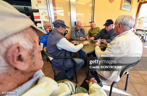 The group old man playing cards out bar in Acciaroli, southern Italy. Situated on the western coast of southern Italy, the town of Acciaroli has a...