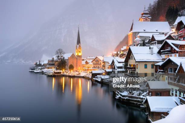 hallstatt unesco typical village with snow at sunset. - hallstatt austria stock pictures, royalty-free photos & images