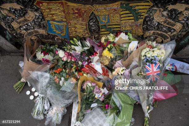Floral tributes to the victims of the March 22 terror attack on Westminster Bridge and the Bruitish parliament are piled on the parapet of...