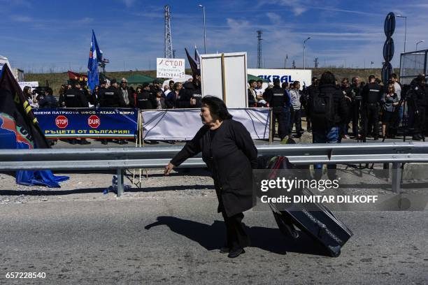 Woman pulls her suitcase as she crosses the Bulgaria-Turkey border on foot during a rally of Bulgarian nationalists aimed at preventing ethnic Turks...