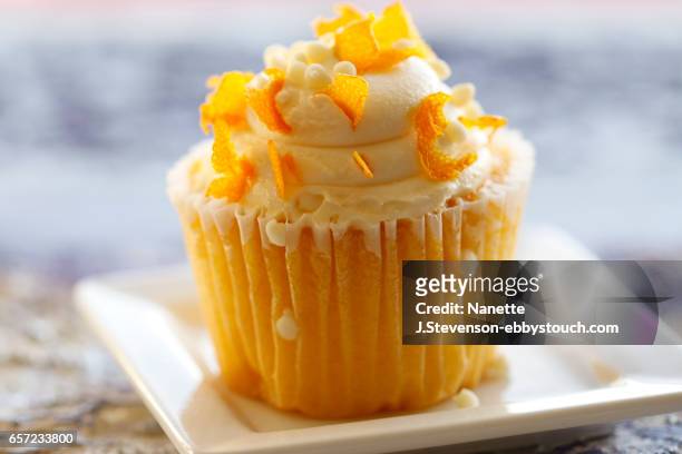 cupcake with orange zest on light background - cupcake stock-fotos und bilder