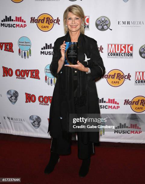 Entertainer Olivia Newton-John, recipient of the Las Vegas Icon award, poses with her trophy during the inaugural Las Vegas F.A.M.E Awards presented...