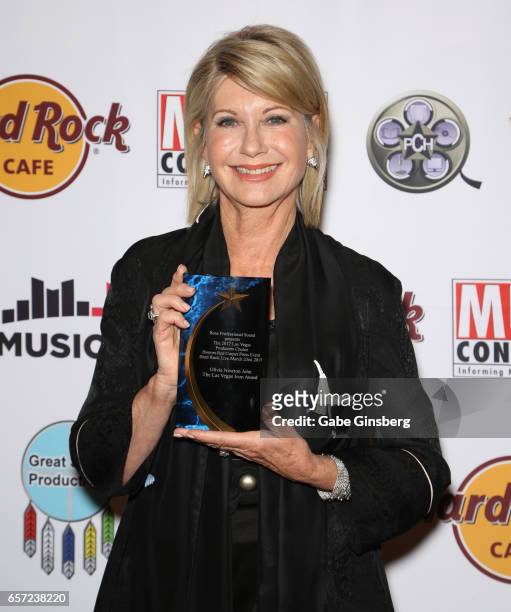 Entertainer Olivia Newton-John, recipient of the Las Vegas Icon award, poses with her trophy during the inaugural Las Vegas F.A.M.E Awards presented...