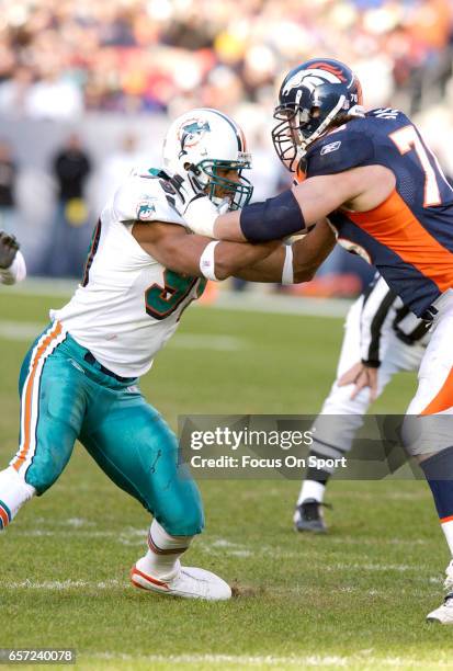 Jason Taylor of the Miami Dolphins rushes up against Matt Lepsis of the Denver Broncos during an NFL football game December 12, 2004 at Mile High...