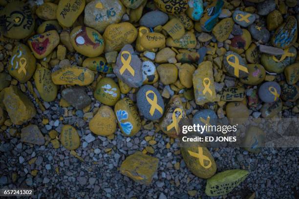 Stones emblazoned with yellow ribbons are displayed near the makeshift homes of relatives of Sewol ferry victims, at Paengmok harbour on South...