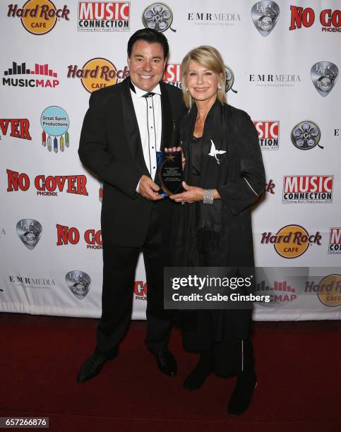 Executive producer Al Bowman and entertainer Olivia Newton-John, recipient of the Las Vegas Icon award, pose with her trophy during the inaugural Las...