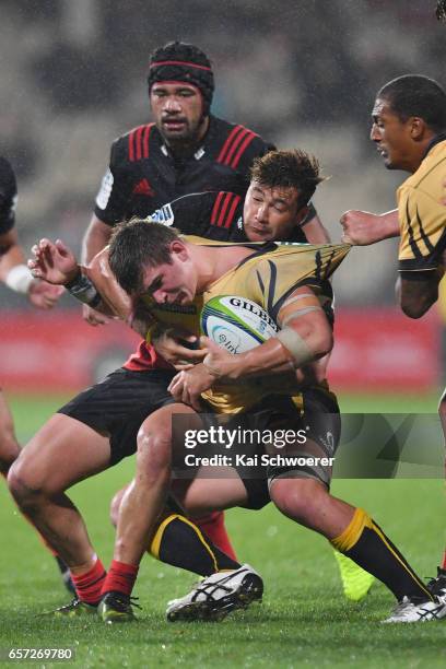 Richard Hardwick of the Force is tackled by David Havili of the Crusaders and Jordan Taufua of the Crusaders during the round five Super Rugby match...