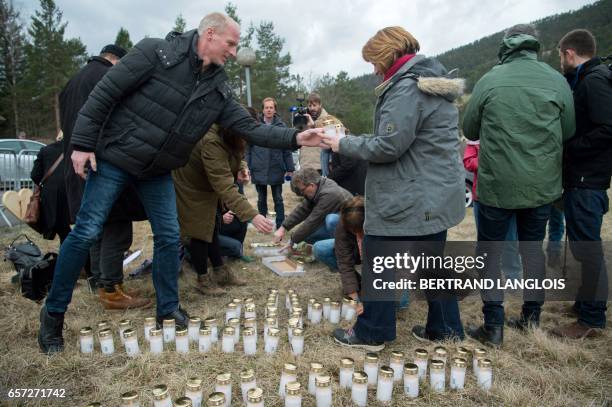 German relatives and friends of victims set candles during the commemoration ceremonies at the Vernet memorial, southeastern France, on March 24,...