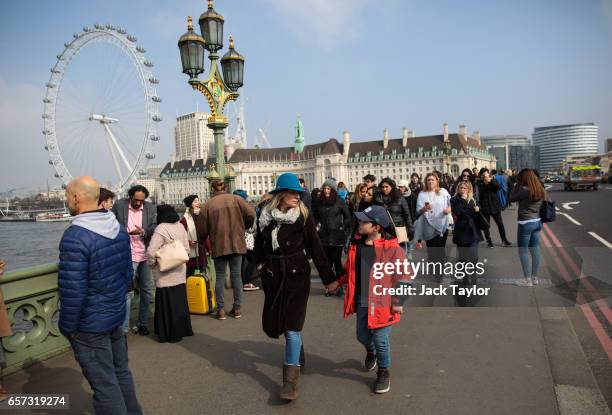 Woman and child walk along Westminster Bridge on March 24, 2017 in London, England. A fourth person has died after Khalid Masood drove a car into...