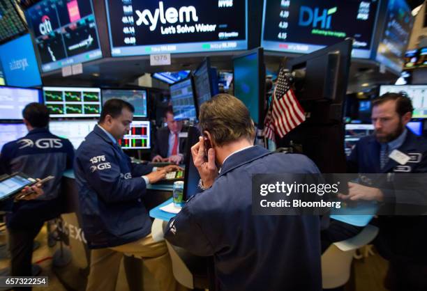 Traders work on the floor of the New York Stock Exchange in New York, U.S., on Friday, March 24, 2017. U.S. Stocks pared the worst weekly drop of the...