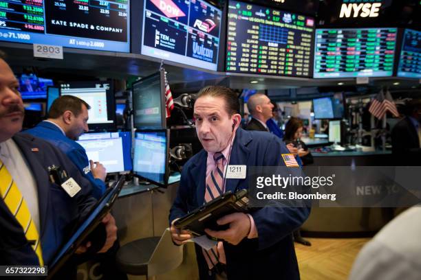 Traders work on the floor of the New York Stock Exchange in New York, U.S., on Friday, March 24, 2017. U.S. Stocks pared the worst weekly drop of the...