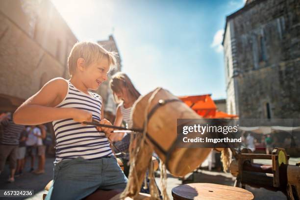 kids tourists having fun on carousel in volterra, tuscany - medieval town stock pictures, royalty-free photos & images