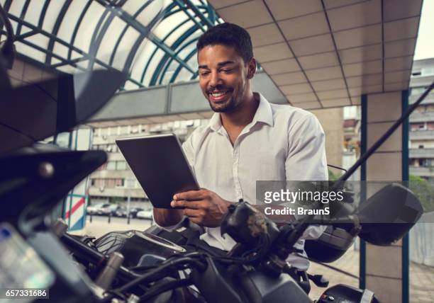 african american businessman using digital tablet on a motorcycle. - bike ipad stock pictures, royalty-free photos & images