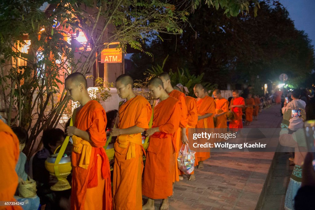 Buddhist monks receiving alms from the people early morning...