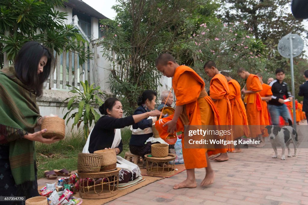 Buddhist monks receiving alms from the people early morning...