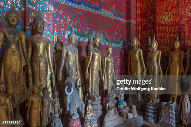 Buddha statues along the wall inside of the Chariot Hall or Royal Funerary Chariot Hall at the Wat Xieng Thong built by King Setthathirath in 1559 in...