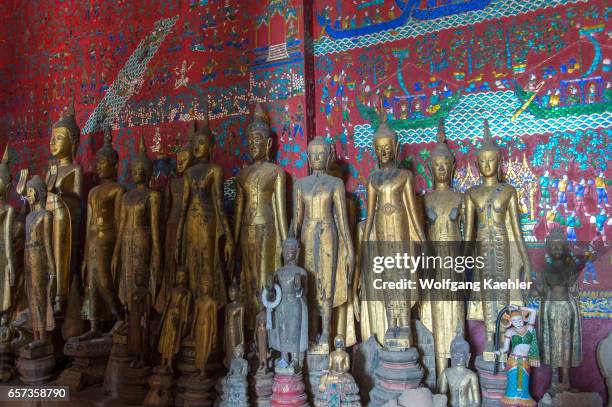 Buddha statues along the wall inside of the Chariot Hall or Royal Funerary Chariot Hall at the Wat Xieng Thong built by King Setthathirath in 1559 in...