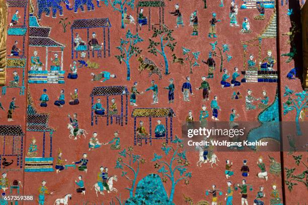 Some of the exterior walls of the buildings at the Wat Xieng Thong in the UNESCO world heritage town of Luang Prabang in Central Laos contain...