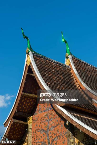 The roof of Wat Xieng Thong in the UNESCO world heritage town of Luang Prabang in Central Laos with stylized Naga finials at the roof?s ends.