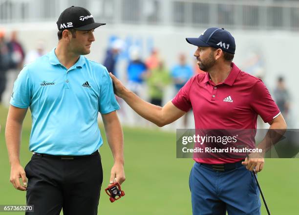 Sergio Garcia of Spain and Jon Rahm of Spain talk after putting on the 13th hole of their match during round three of the World Golf...