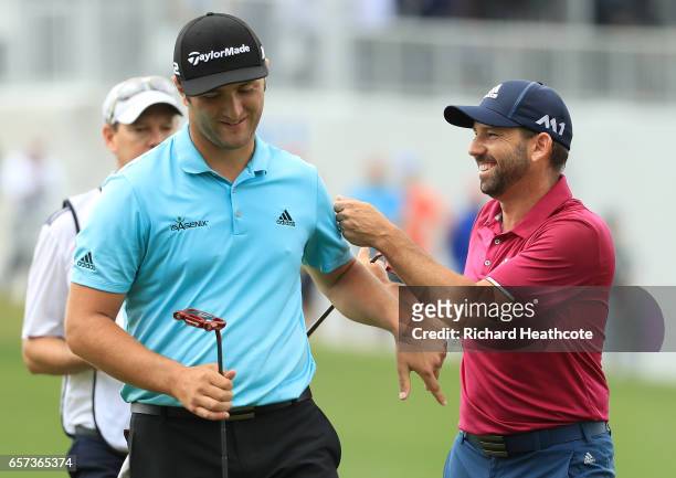 Sergio Garcia of Spain and Jon Rahm of Spain talk after putting on the 13th hole of their match during round three of the World Golf...
