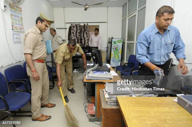 Police personnel clean the office at police station on March 24, 2017 in Noida, India. New UP Chief Minister Yogi Adityanath has ordered that the...