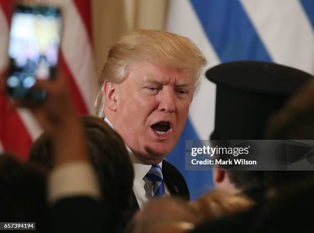 President Donald Trump greets guests during a Greek Independence Day celebration in the East Room of the White House, on March 24, 2017 in...