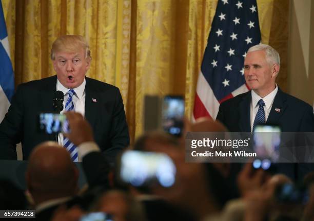 President Donald Trump speaks to guests while flanked by Vice President Mike Pence during a Greek Independence Day celebration in the East Room of...