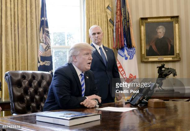 President Donald Trump reacts with Vice President Mike Pence after Republicans abruptly pulled their health care bill from the House floor, in the...