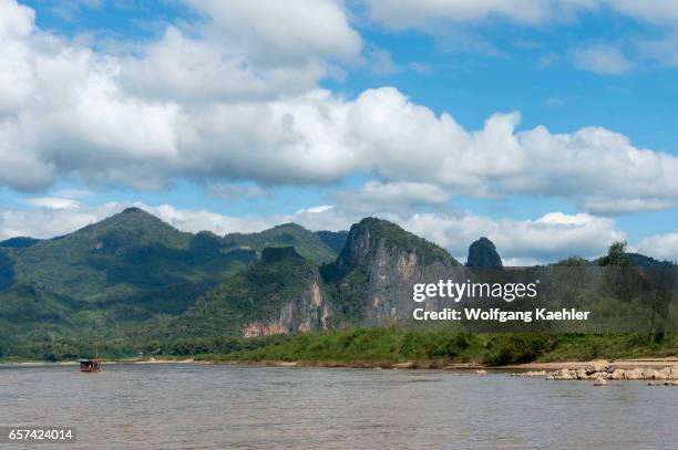 View of the Mekong River with an excursion boat and landscape on the way to Pak Ou Cave near Luang Prabang in Central Laos.