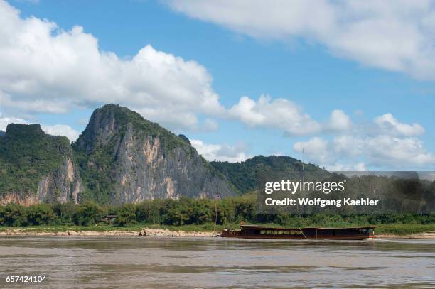 View of the Mekong River with an excursion boat and landscape on the way to Pak Ou Cave near Luang Prabang in Central Laos.