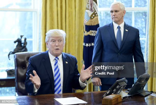 President Donald Trump reacts with Vice President Mike Pence after Republicans abruptly pulled their health care bill from the House floor, in the...