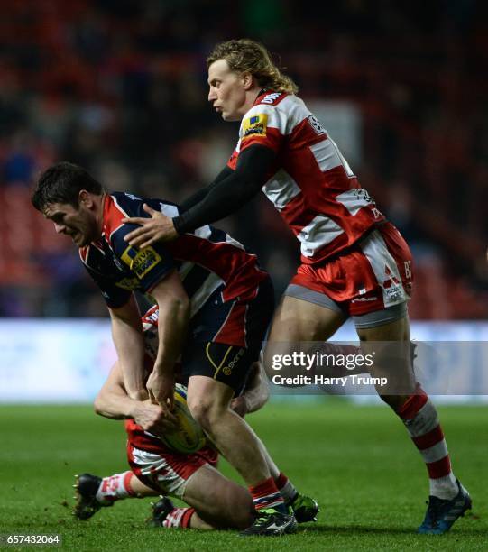 Marc Jones of Bristol Rugby is tackled by Jonny May of Gloucester Rugby and Billy Twelvetrees of Gloucester Rugby during the Aviva Premiership match...