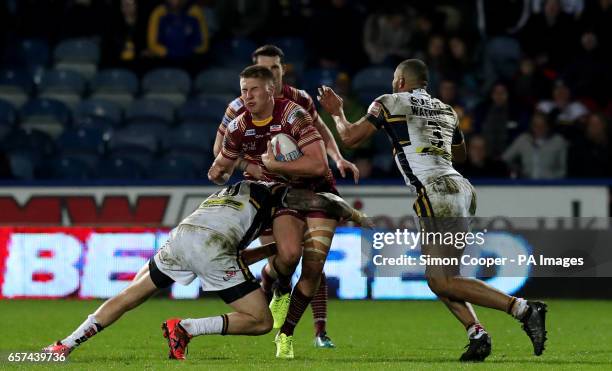 Huddersfield Giants' Alex Mellor is tackled by Leeds Rhinos' Kallum Watkins and Adam Cuthbertson during the Betfred Super League match at the John...