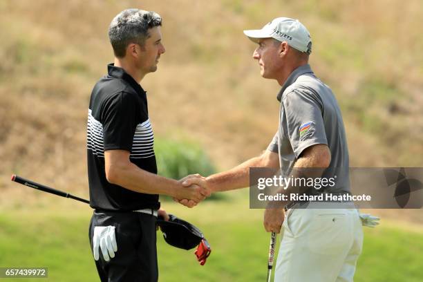 Ross Fisher of England shakes hands with Jim Furyk after winning their match 3&2 on the 16th hole during round three of the World Golf...