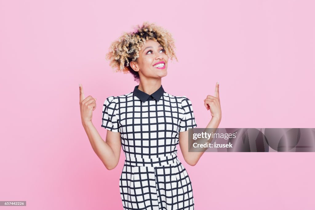 Hermoso afro americano joven señalando en el espacio de copia