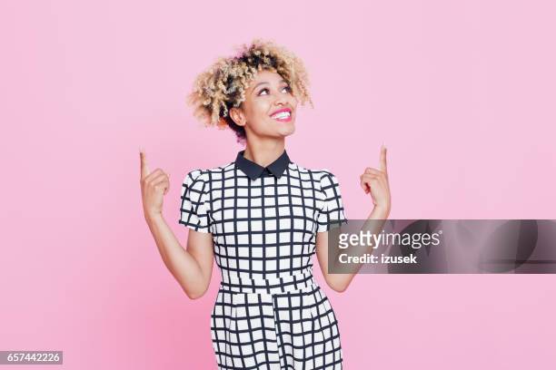 vackra afro amerikansk ung kvinna pekar på kopia utrymme - woman looking up bildbanksfoton och bilder