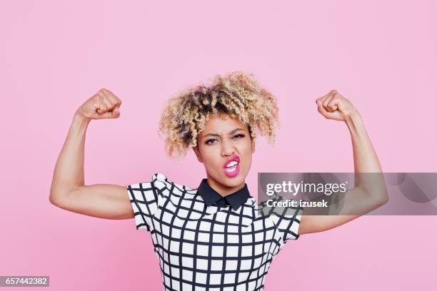 strong afro american young woman flexing muscles - muscular build stock pictures, royalty-free photos & images