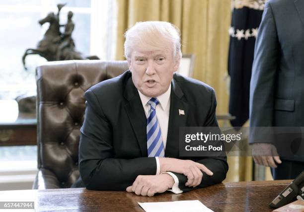 President Donald Trump reacts after Republicans abruptly pulled their health care bill from the House floor, in the Oval Office of the White House on...