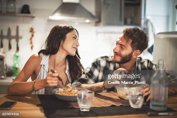young couple eating together at home - 2017 vanity fair dinner or inside stock pictures, royalty-free photos & images