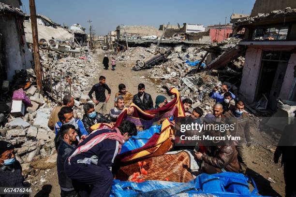 Residents pile up body bags in the back of a pick up truck after recovering it from the rubble where there were reported coalition air strikes in the...