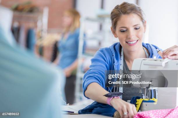 happy seamstress at work - pin cushion stock pictures, royalty-free photos & images