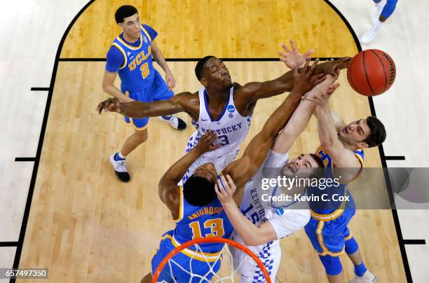 Isaiah Briscoe and Isaac Humphries of the Kentucky Wildcats compete for the ball with Ike Anigbogu and Gyorgy Goloman of the UCLA Bruins in the first...