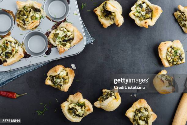 puff pastry mini tarts with feta cheese and spinach, , top view with copy space for recipe - spinach pie stock pictures, royalty-free photos & images