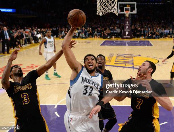 Karl-Anthony Towns of the Minnesota Timberwolves is surrounded by Corey Brewer Larry Nance Jr. #7 and David Nwaba of the Los Angeles Lakers as the...