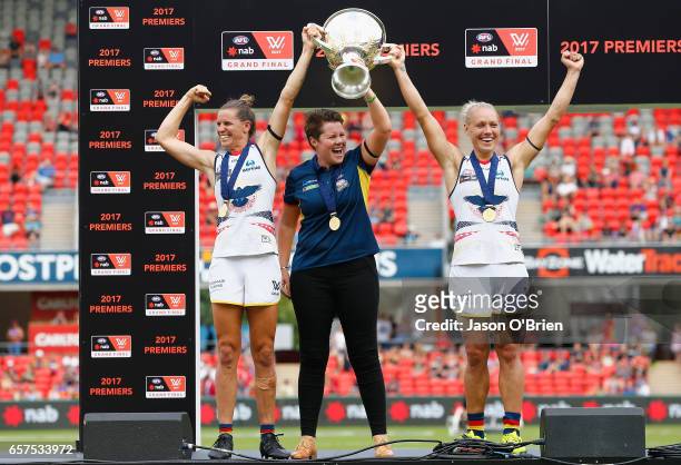 Crows coach Bec Goddard lifts the trophy with Erin Phillips and Chelsea Randall during the AFL Women's Grand Final between the Brisbane Lions and the...
