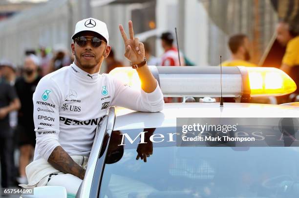 Polesitter Lewis Hamilton of Great Britain and Mercedes GP celebrates in parc ferme during qualifying for the Australian Formula One Grand Prix at...