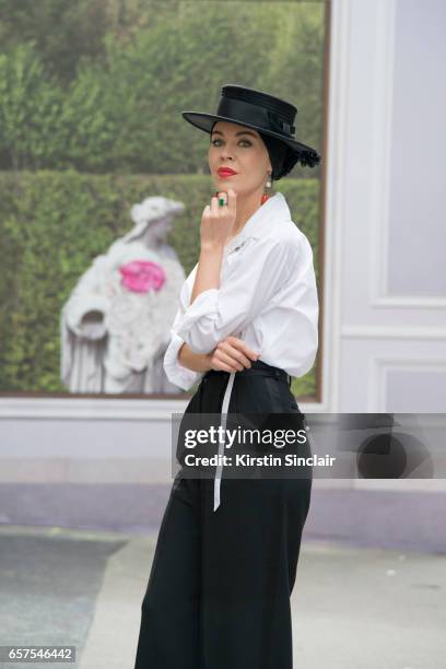 Fashion designer Ulyana Sergeenko wears a Chanel blouse, Dolce & Gabbana trousers and Stephen Jones hat day 2 of Paris Haute Couture Fashion Week...