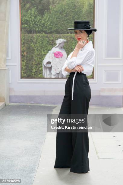 Fashion designer Ulyana Sergeenko wears a Chanel blouse, Dolce & Gabbana trousers and Stephen Jones hat day 2 of Paris Haute Couture Fashion Week...