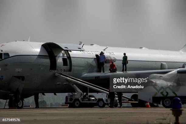 Crew members of a US Air Force Boeing 707 aircraft conduct a ground inspection at Sultan Iskandar Muda Airport in Aceh Besar, Aceh province, on March...